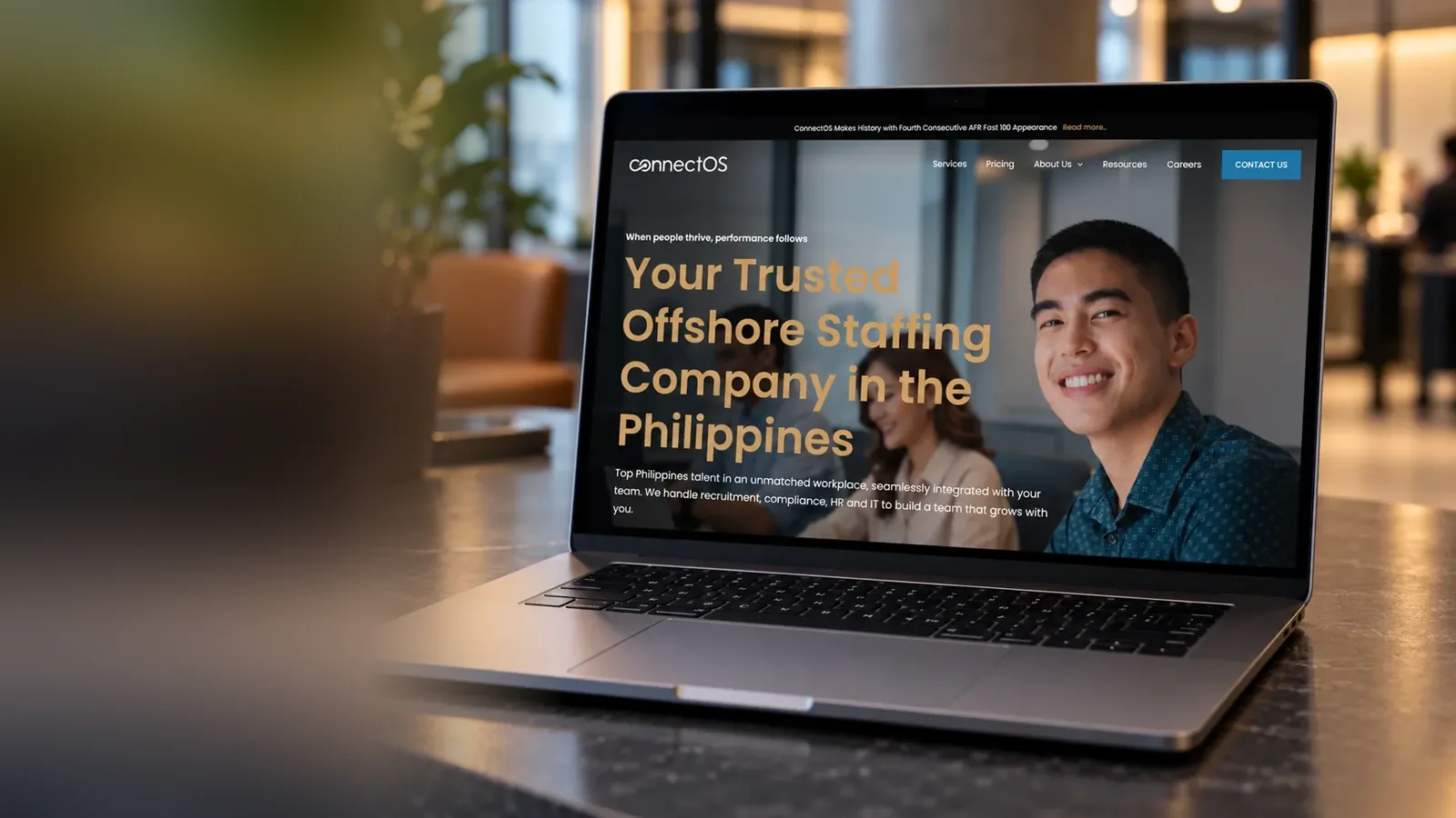 The ConnectOS website on a laptop in a business lounge